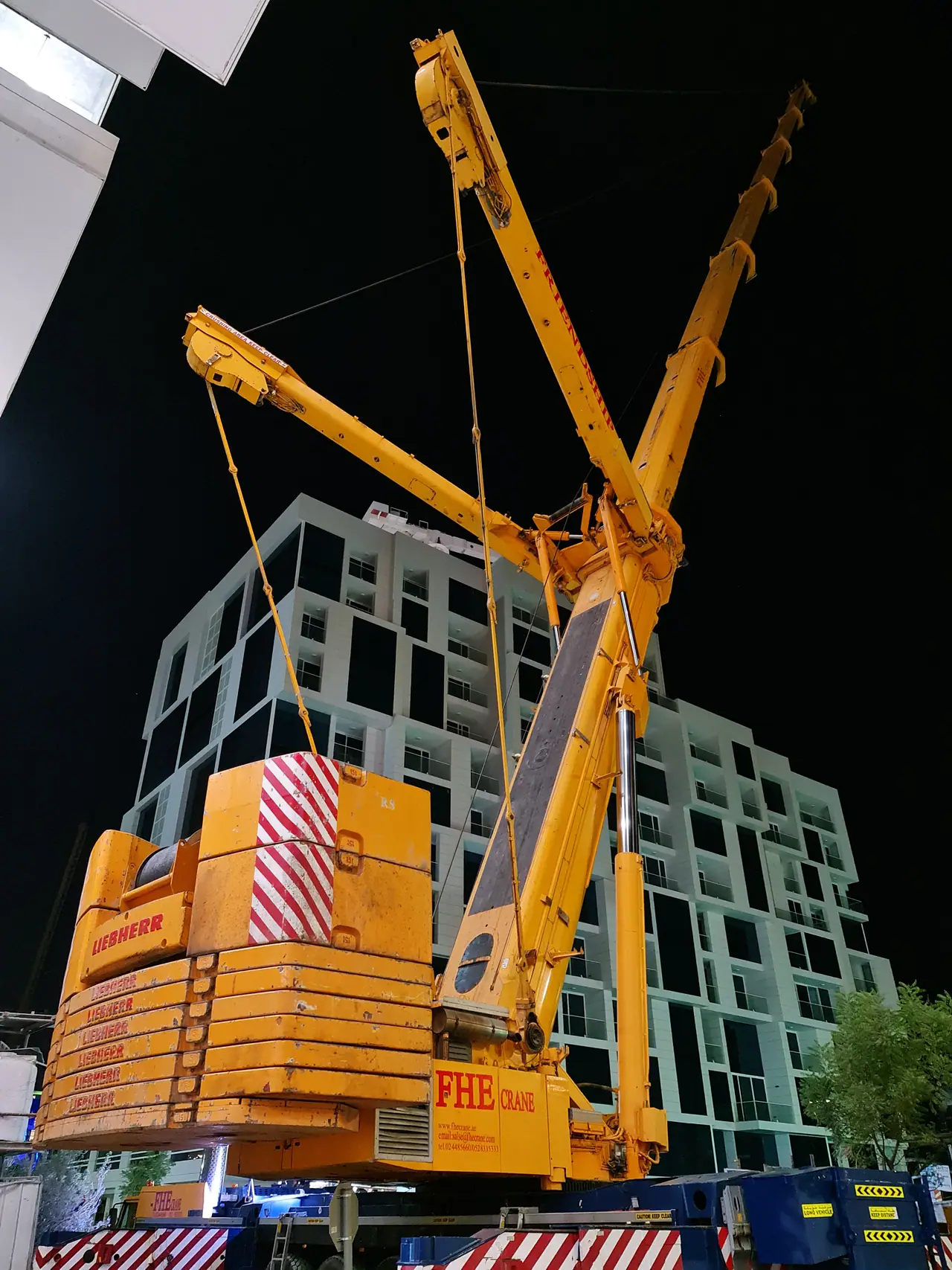 FHS heavy crane with superlift counterweight working at night