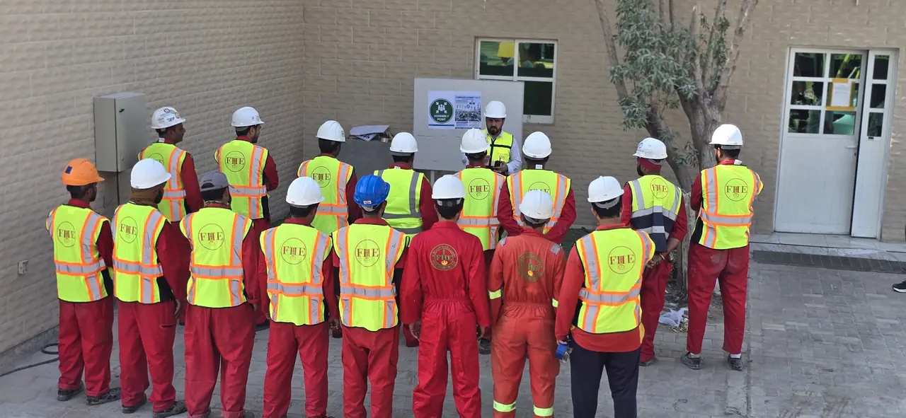 FHS crew gathered at the emergency assembly point sign, seen from behind